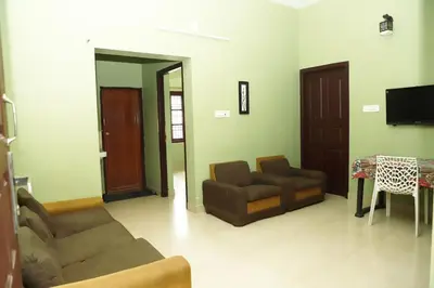a living room with two couches and a table at Clement homes in Kalpetta