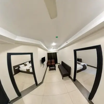 two mirrors in a room with two beds at Gokulam Suits Guruvayur in Guruvāyūr
