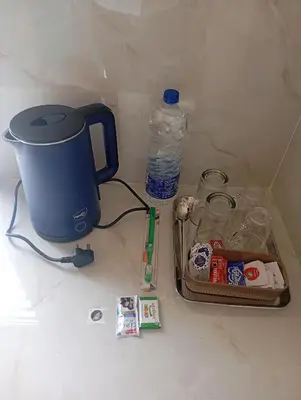 a table with a coffee maker and a bottle of water at PURAYIL Rooms in Kozhikode