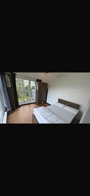 a bedroom with two beds and a window at Artists getaway in Kodaikānāl