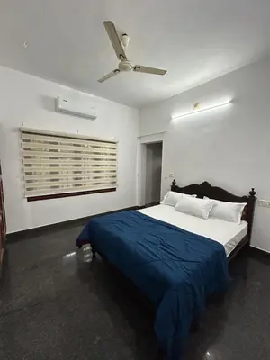 a bedroom with a bed and a ceiling fan at Entire 4BHK House with Full Kitchen near malayattoor in Kodanad