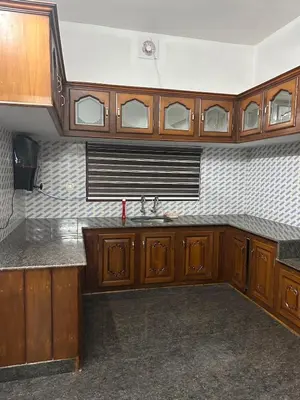 an empty kitchen with wooden cabinets and a sink at Entire 4BHK House with Full Kitchen near malayattoor in Kodanad