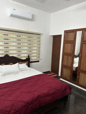 a bedroom with a large bed and a window at Entire 4BHK House with Full Kitchen near malayattoor in Kodanad