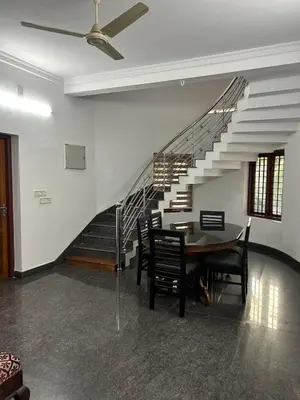 a dining room with a table and a staircase at Entire 4BHK House with Full Kitchen near malayattoor in Kodanad