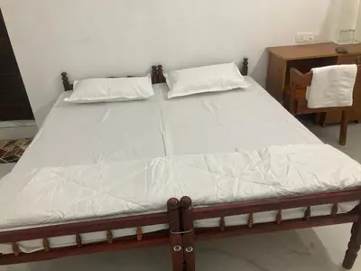 a bed with two pillows on it in a room at vhost in Alwaye
