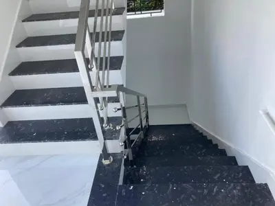 a staircase with black flooring in a room at vhost in Alwaye