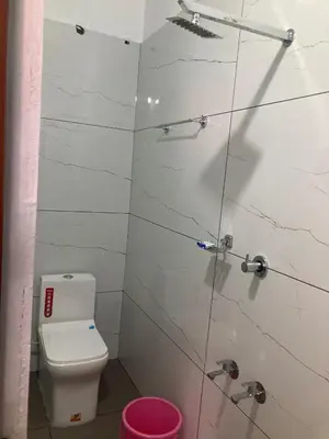 a bathroom with a toilet and a glass shower stall at vhost in Alwaye