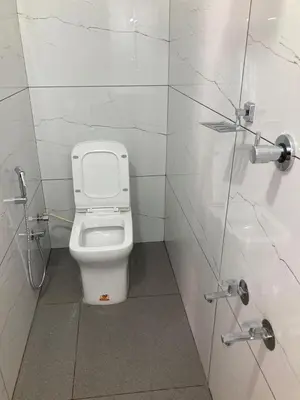 a bathroom with a white toilet in a stall at vhost in Alwaye