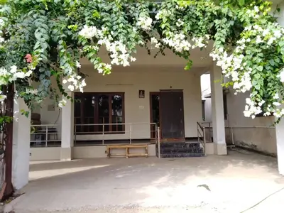 an entrance to a building with a bench under a tree at SHI's Triveni Spacious 2BHK Villa in Pappampatti in Chettipālaiyam