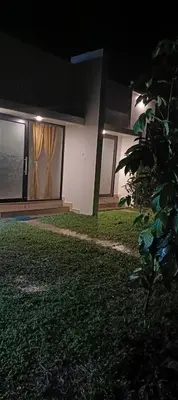 a house at night with a lawn in front of it at Metta Heaven in Kodenchery