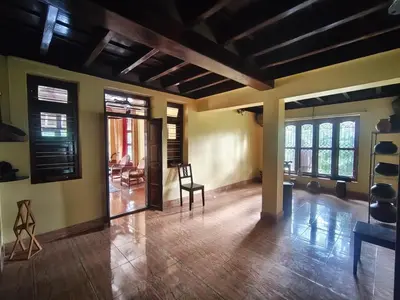 a living room with a table and a chair at Heritage Mudhouse Homestay in Virajpet