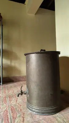 a metal bucket sitting on top of a floor at Heritage Mudhouse Homestay in Virajpet