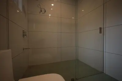 a bathroom with a glass shower with a toilet at Kadmane Resort in Kākankote