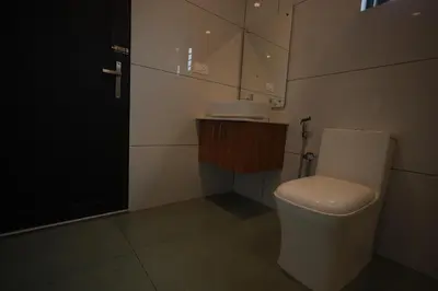 a bathroom with a white toilet and a sink at Kadmane Resort in Kākankote