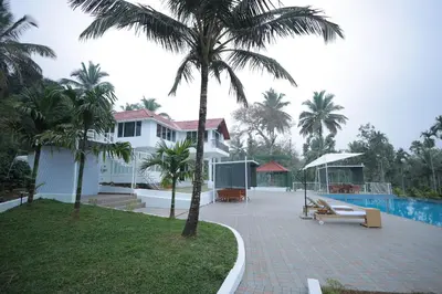 a house with a palm tree and a swimming pool at Kadmane Resort in Kākankote