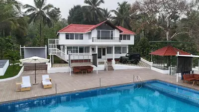 a villa with a swimming pool and a house at Kadmane Resort in Kākankote