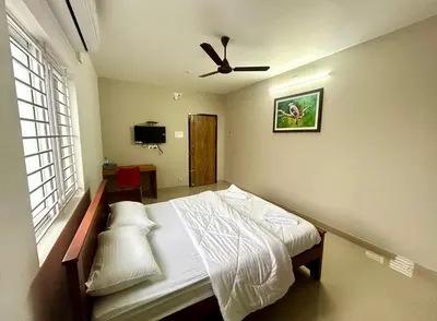 a bedroom with a bed and a ceiling fan at BR Farm Stay in Coimbatore