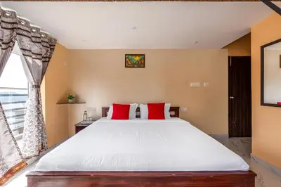 a bedroom with a large bed with red pillows at Orchid Villa Kotagiri in Kodanād