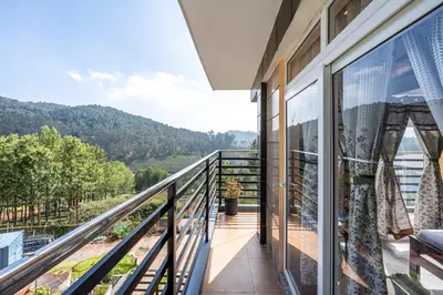 a balcony with a view of the mountains at Orchid Villa Kotagiri in Kodanād