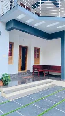 a building with two benches in front of a building at The Wayanad Stays in Kalpetta