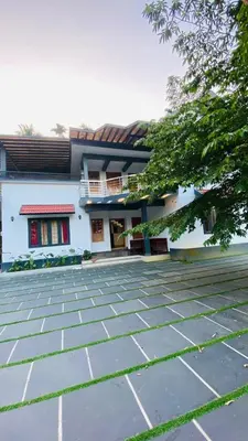a white building with a patio in front of it at The Wayanad Stays in Kalpetta