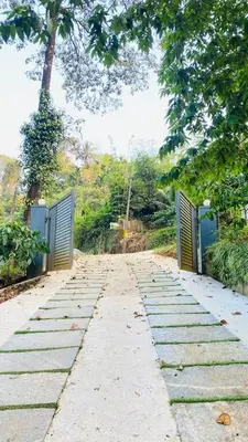a walkway with two gates in a park at The Wayanad Stays in Kalpetta