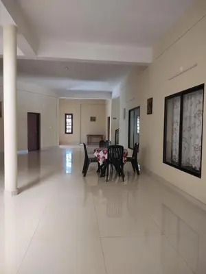 a large living room with chairs and a table at Bridgettine Paradise in Sultan Bathery