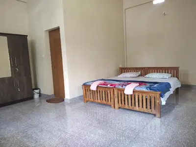 a bedroom with a bed with a wooden frame at Bridgettine Paradise in Sultan Bathery