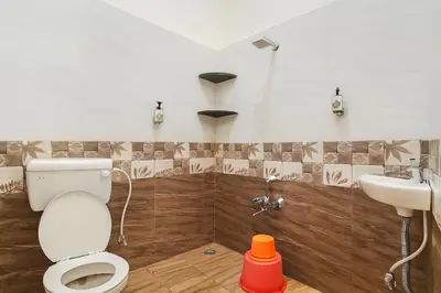 a bathroom with a toilet and a sink at Stayz Royale - Mysuru near Mysuru Palace in Mysore