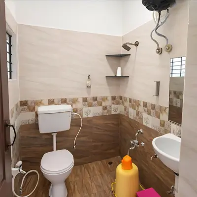 a bathroom with a toilet and a sink at Stayz Royale - Mysuru near Mysuru Palace in Mysore