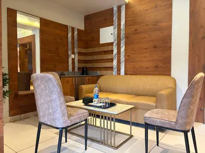 a living room with a couch and a table and chairs at Raravies family restaurent Mattanur,Near Kannur airport in Chāvasseri