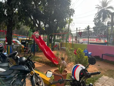 a man sitting on a slide at a playground at Raravies family restaurent Mattanur,Near Kannur airport in Chāvasseri