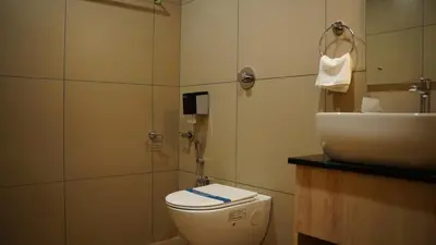 a bathroom with a toilet and a sink at VOX holiday in Palakkad