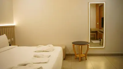 a bedroom with a bed and a table and a mirror at VOX holiday in Palakkad