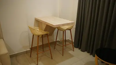 a wooden table and two stools in a room at VOX holiday in Palakkad