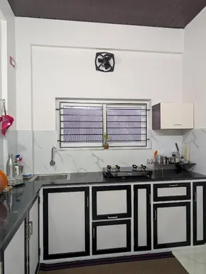 a kitchen with a black and white counter top at Eva's Homestay at Cherai in North Paravur