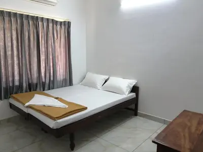 a bed in a room with a curtain and a bed sidx sidx sidx at GG Residency INN in Palakkad