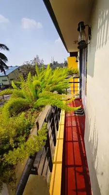 a balcony with potted plants on the side of a building at Steeva service apartment in Mysore