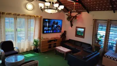 a living room with a couch and a flat screen tv at Steeva service apartment in Mysore