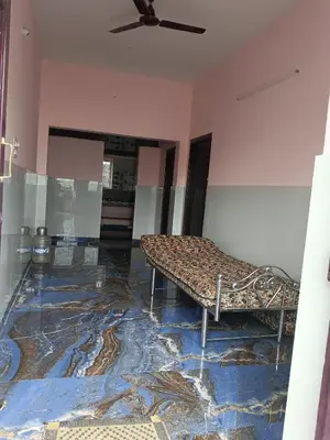 a bed in a room with a ceiling fan at Sona rooms in Coimbatore