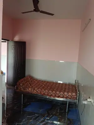 a bed in a room with a ceiling fan at Sona rooms in Coimbatore