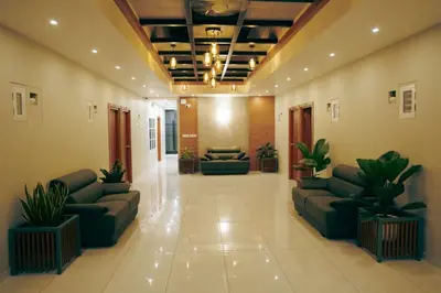 a lobby with couches and plants in a building at Neom Inn in Wayanad