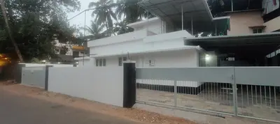 a white fence in front of a building at Ivory Suites Meadows in Kozhikode