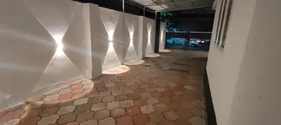 a hallway with a tile floor and white walls at Ivory Suites Meadows in Kozhikode
