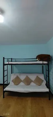 a black bunk bed with three pillows on it at Jay bahadur Cottages and home stay in Ooty