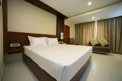 a bedroom with a large white bed in a room at Vavas Inn & Suites in Perintalmanna