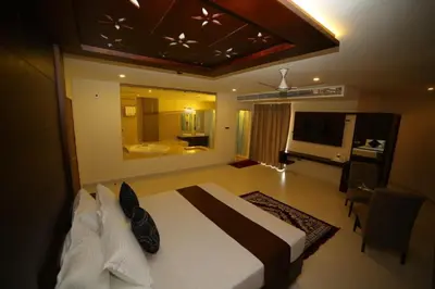a bedroom with a large bed and a bathroom at Vavas Inn & Suites in Perintalmanna