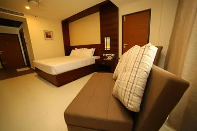 a hotel room with a bed and a couch at Vavas Inn & Suites in Perintalmanna