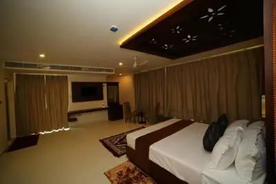 a hotel room with a bed and a television at Vavas Inn & Suites in Perintalmanna