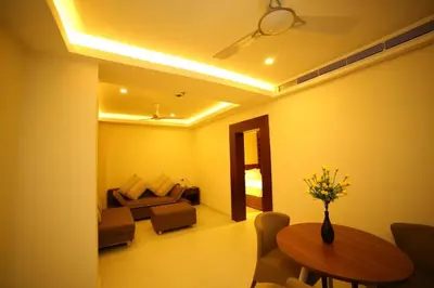 a living room with a table and a couch at Vavas Inn & Suites in Perintalmanna